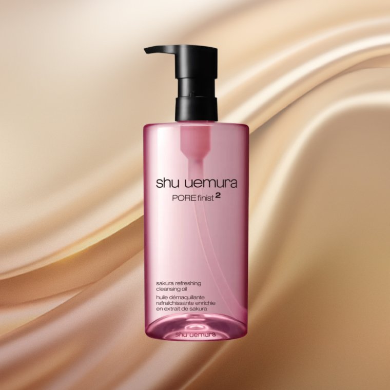 Bottle of Shu Uemura Porefinist2 Sakura Refreshing Cleansing Oil on a textured background