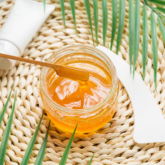 Picture of a pot of wax surrounded by leaves
