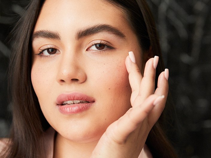 Picture of a model lightly touching their under-eye area