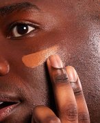 Male model applying foundation