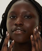 Picture of a model touching the sides of their face, looking at the camera