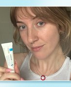 Photo of the editor holding the La Roche-Posay Cicaplast Lips Hydration Restore Lip Balm against a light blue graphic background