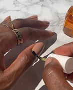 Picture of a person applying cuticle oil to their thumb