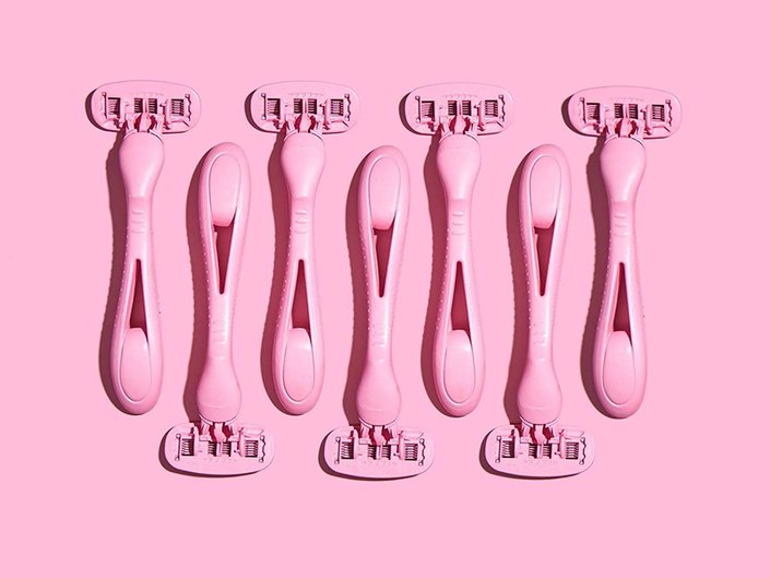 Picture of seven pink razors on a matching pink background
