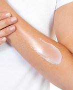 Close-up of a hand applying a soothing salve to cracked skin, illustrating the use of different skin treatment products.