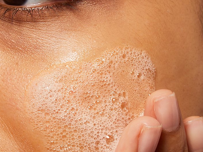 Person with facial cleanser on skin