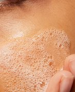 Person with facial cleanser on skin