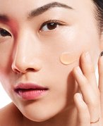 Photo of a woman and applying moisturizer to her cheek