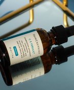 Bottle of the SkinCeuticals C E Ferulic Serum turned over on a mirrored counter
