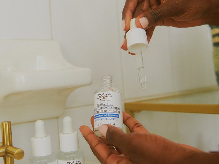 Hands holding an open bottle of Kiehl’s Ultra Pure High-Potency 1.5% Hyaluronic Acid Serum.